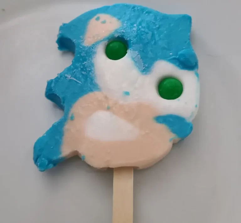 A partially melted Sonic popsicle with gumball eyes on a plate.